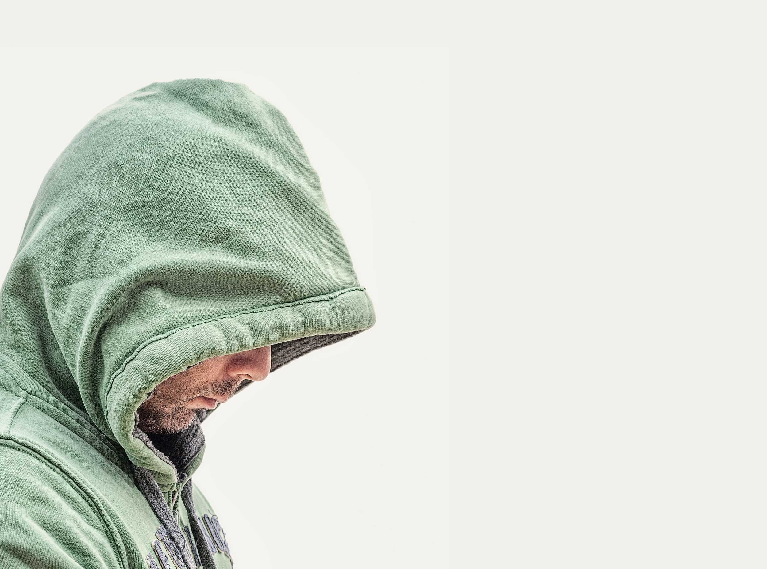 Man in hood jumper struggling from addiction