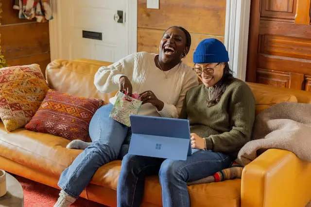 2 women sitting on sofa at home