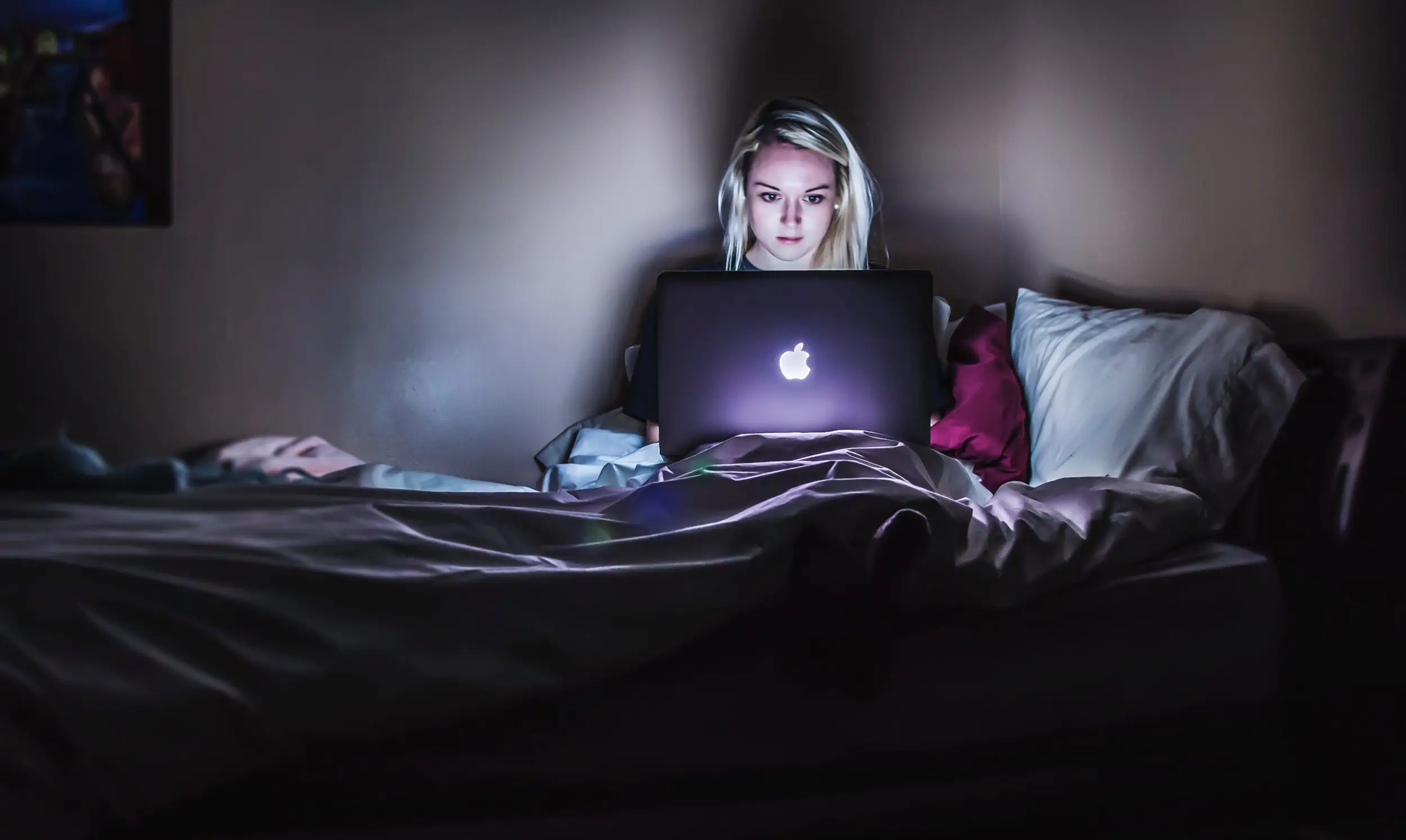 A women watching laptop screen in the dark room